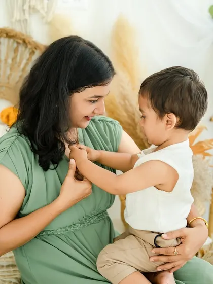 A gentle dance between a mother and her little boy. This playful interaction shows their loving connection in a dynamic and sweet way.