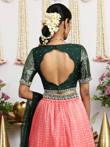 The back view of the deep green blouse paired with the coral pink lehenga, showcasing the beautiful contrast.