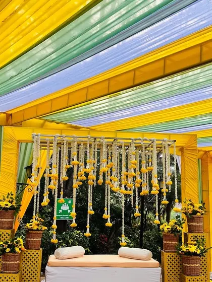 The colorful striped canopy creates a festive and cheerful atmosphere for this Haldi celebration.