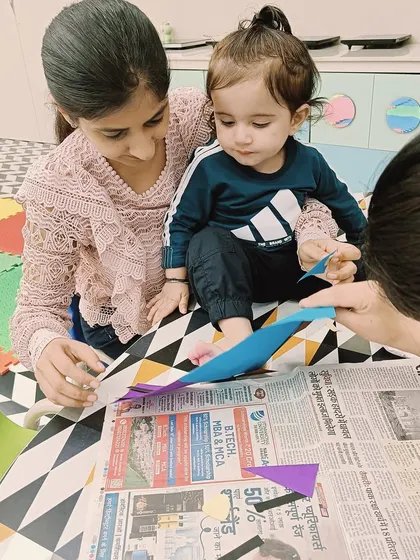A mother and daughter work on a craft at a small table, a typical setup in our Ashok Vihar class that encourages focused work.
