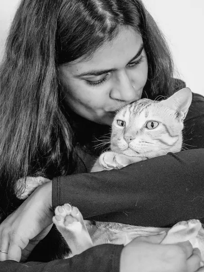 A tender black and white photo of Akanksha and her cat, Jerry. The monochrome tones emphasize the quiet affection and peacefulness of the moment.