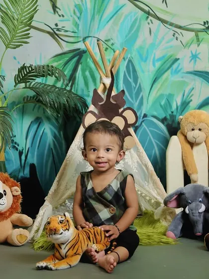 A little explorer in our jungle safari setup. Surrounded by plush animals like a lion, tiger, and panda, this theme is perfect for adventurous kids.