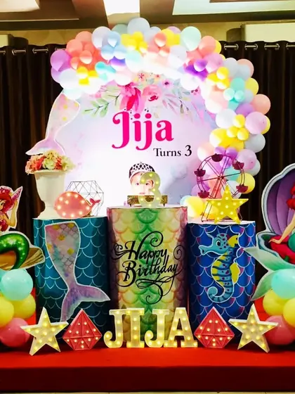 A colorful Little Mermaid party for Jija's third birthday. This setup is filled with vibrant balloons and underwater elements like seahorses and shells.