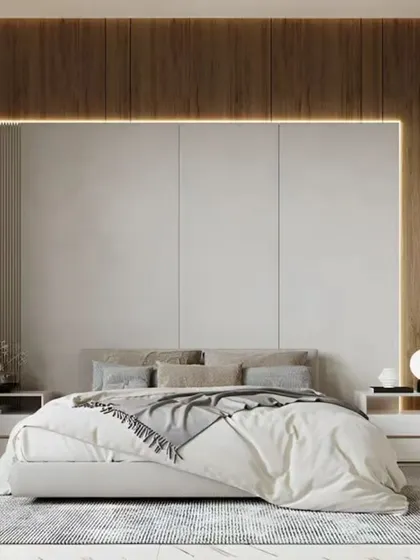 This serene bedroom uses a combination of wood and fabric panels for the headboard wall, with modern sconces providing soft, ambient light.