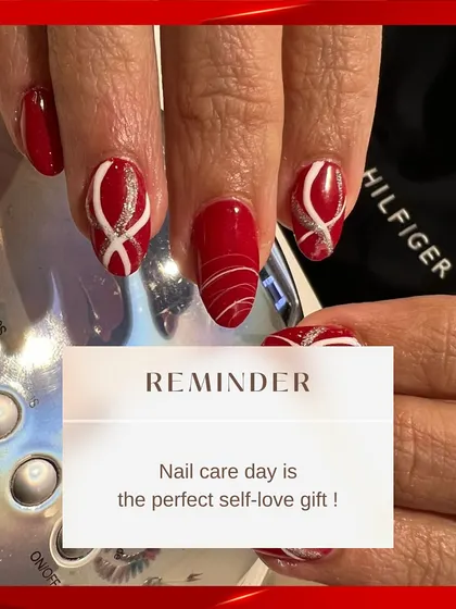 A bold and festive nail art design. This set features a vibrant red base with intricate white and silver glitter swirls, making it perfect for holidays or celebrations.