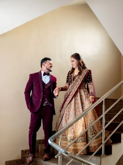 A happy, candid shot of a couple walking down the stairs at their reception, sharing a laugh.