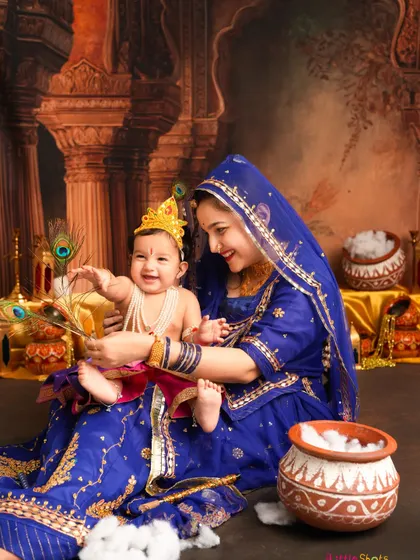 A playful moment during our Janmashtami shoot. Little Krishna reaches for a peacock feather, held by his loving mother dressed as Yashoda.