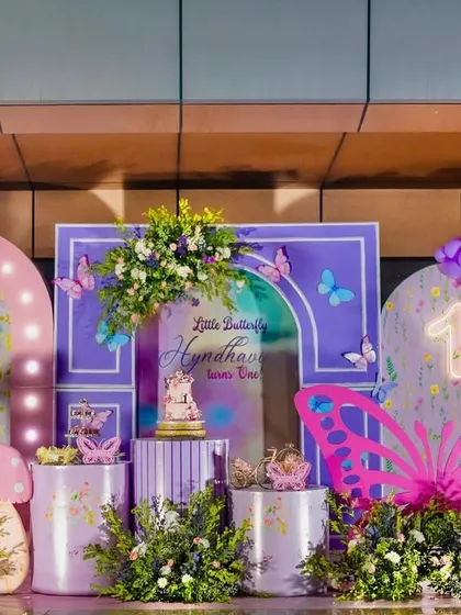 A vibrant and playful butterfly-themed party setup. I used a bold purple and pink color palette, oversized butterfly props, and fun character cutouts like a teddy bear to create a joyful and eye-catching celebration.