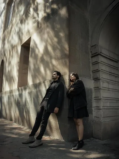 Leaning against a wall, bathed in the dappled sunlight filtering through the trees. This is a moment of quiet contemplation, a peaceful pause in their city adventure.