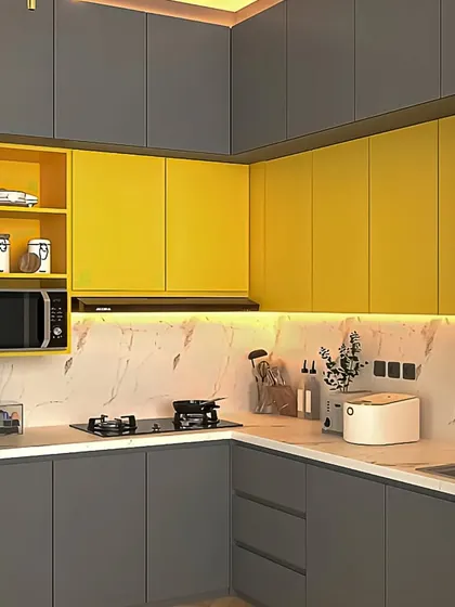 This L-shaped kitchen pairs sunny yellow upper cabinets with dark grey base units. The marble-look backsplash adds a touch of elegance.