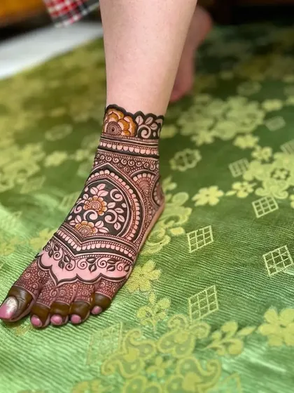 This design features a central floral mandala on the foot with a matching band on the ankle. It's a classic and beautiful choice for any occasion.