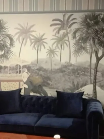 A sophisticated black and white mural of a tropical landscape with elephants, creating a dramatic and elegant atmosphere in this living room.