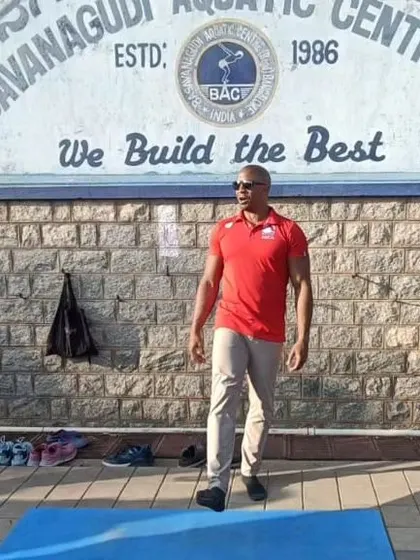 Coach Atiba Wade, an elite trainer, stands in front of our iconic "We Build the Best" sign. We regularly bring in experts to provide our athletes with the best in fitness and nutrition coaching.