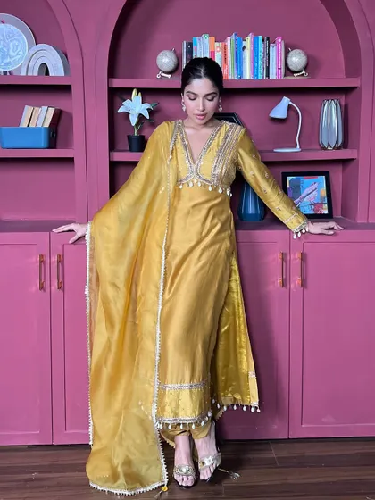 The full view of this mustard yellow suit against a contrasting pink background. It shows how to create a visually striking image.