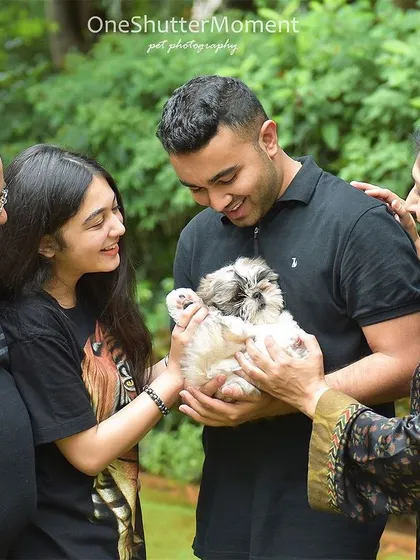 The absolute favorite of the family. This tiny Shih Tzu puppy is the center of attention, surrounded by the loving smiles of his new family members.