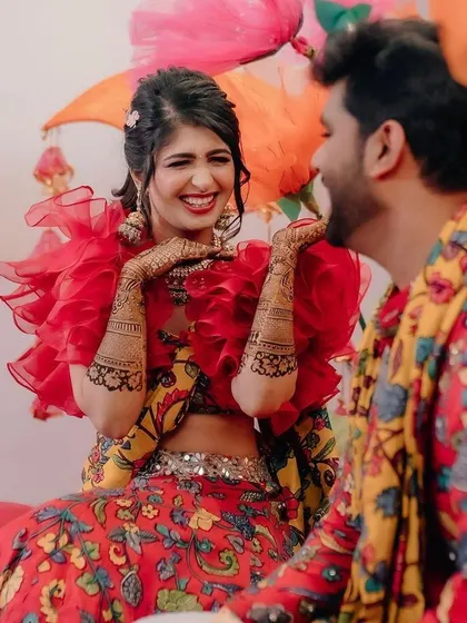 Fun and candid moments from a vibrant Mehendi event. The couple is sharing a laugh, surrounded by the bright, festive atmosphere I designed for their special day.