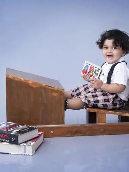 A happy little student at his desk, laughing as he holds an ABC book. This theme is a wonderful way to capture the excitement of learning and growing up.