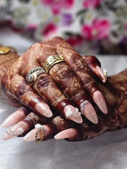 For my brides, every detail matters. I design custom bridal nails that complement the intricate henna and wedding attire. This set features delicate 3D flowers and chain details for a look that's both traditional and modern.