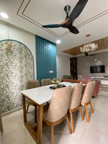 The dining space is defined by unique wall treatments, including a floral wallpapered arch and a textured teal panel, which add color, pattern, and architectural interest.