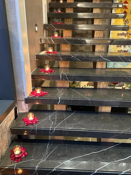 Small details make a big impact. We placed small candles in beds of rose petals along the steps of this marble staircase, lighting the way for guests and adding to the home's festive feel.