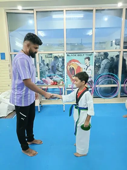 A handshake for a new green and blue belt.