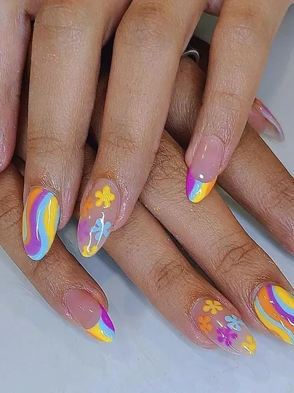 A vibrant and playful set of almond nails, featuring a mix of rainbow swirls and hand-painted flowers for a fun, retro vibe.
