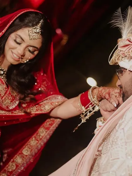 A quiet, tender moment between the bride and groom on their wedding day. The groom's gentle kiss on her forehead captures the deep affection and emotion of the day, highlighted by warm, soft lighting.