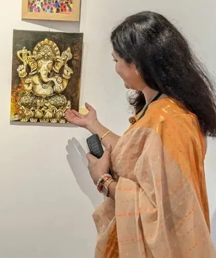 A visitor admiring my 'Panchaloha Ganesha' painting at the exhibition. The 3D texture and metallic finish are best appreciated in person.