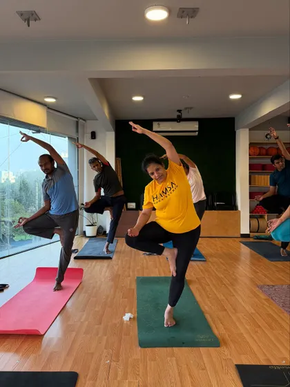 A fun, dynamic shot of students in a balancing pose, moving and breathing together.