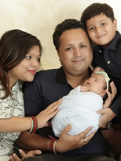 A classic family portrait with the parents and older brother gathered around the newborn. A timeless keepsake for a growing family.