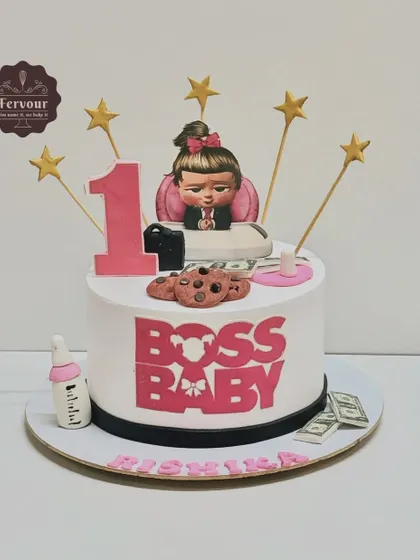 A cute Boss Baby-themed cake for a first birthday. This design features the "boss baby" girl character, along with fun details like edible money, cookies, and a baby bottle.