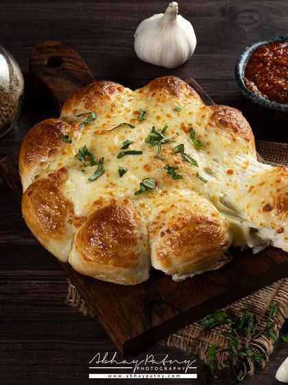 The key to this cheesy garlic bread shot was to capture the "cheese pull" feel. I used lighting from the side to create depth and highlight the golden-brown crust and gooey cheese.