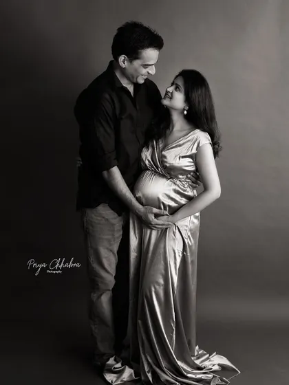 A classic black and white portrait. The simplicity of the monochrome tones adds a timeless and elegant quality to this beautiful moment between the expecting parents.