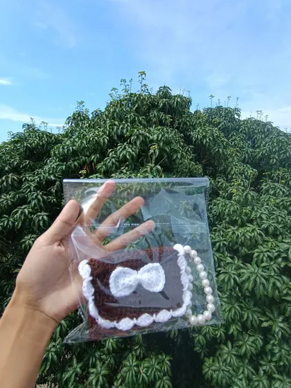 A brown and white pocket purse, individually packaged and ready for sale. I ensure all items are professionally presented for my wholesale clients.