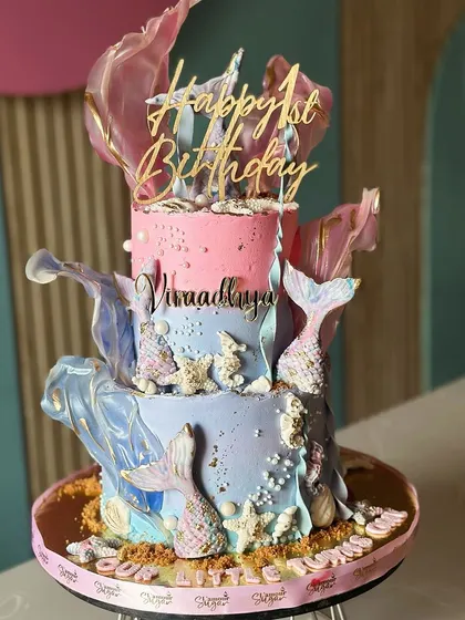 Dive into a sea of sweetness with our mermaid-themed tall cake. Featuring pastel waves, shimmering tails, and edible sea treasures, it's perfect for making waves at any party.