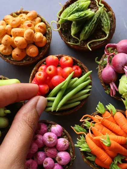 A close-up of a basket of miniature tomatoes and beans.
