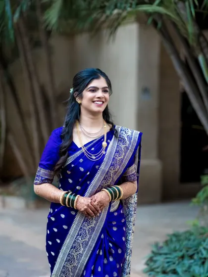 The bride walking with a joyful expression. This candid shot captures her movement and the flow of her beautiful silk saree.