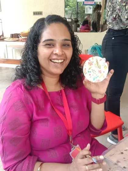 A participant proudly showing her finished decoupage coaster.