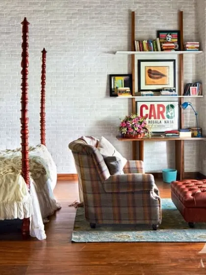 The bedroom in Kangana Ranaut's home, with a classic four-poster bed set against a white-washed brick wall. The design is a mix of rustic charm and timeless elegance, creating a serene and personal retreat.