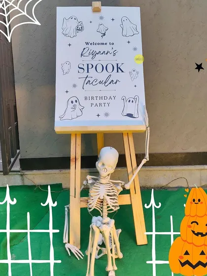 A spooktacular welcome! The entrance to the Halloween birthday party featured a skeleton, pumpkin props, and a custom-designed easel board to set a fun and spooky tone right from the start.