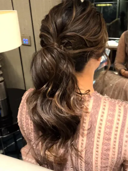 A messy, textured low ponytail, a chic and effortless-looking style for a modern event.