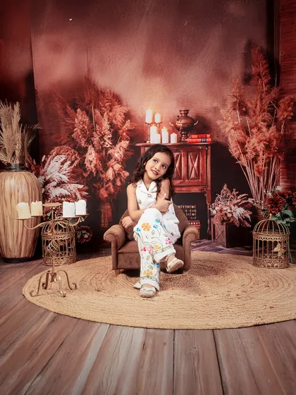 A portrait of a graceful older sister, sitting elegantly in our rustic, warm-toned studio setup.