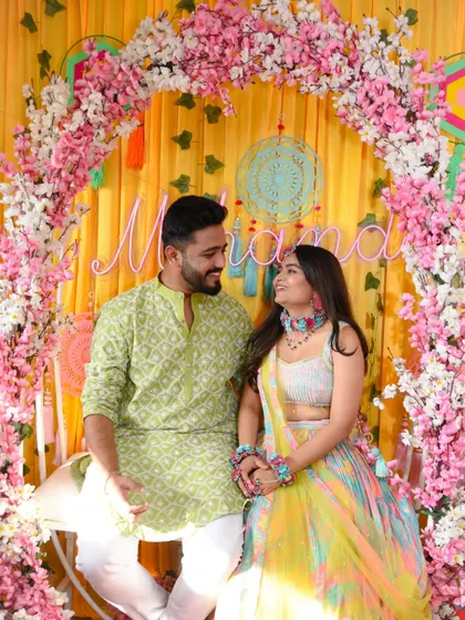 A sweet, candid moment between the couple during their Mehendi, sharing a loving look.