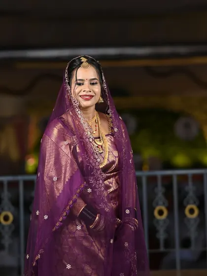 A full-length shot of the bride, showcasing her beautiful purple saree and veil.