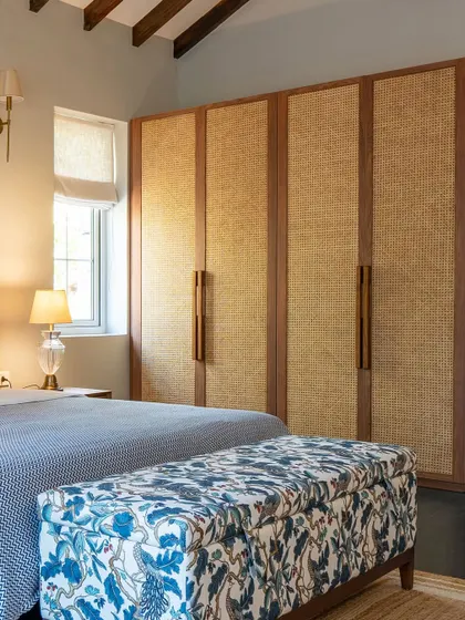 A custom wardrobe with natural rattan paneling in our Goa villa project. The warm wood frame and textured doors complement the room's relaxed, coastal aesthetic, providing ample storage without compromising on style.