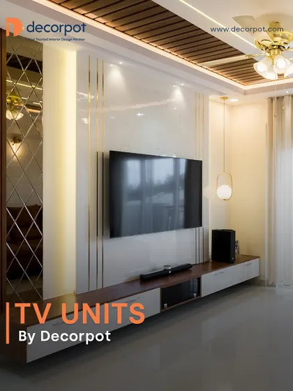 A classic and elegant TV unit design featuring a rich wood console, a glossy white back panel with gold accents, and a mirrored side panel. The wooden false ceiling ties the entire look together.