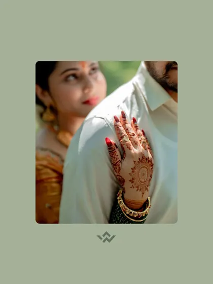 A close-up on the bride's hand, adorned with mehendi, resting on the groom's shoulder. This simple, tender gesture is full of love and meaning.