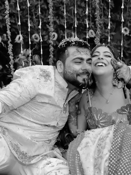 A black and white take on the playful chaos of Haldi. The groom holds a water gun, ready for fun, capturing a moment of pure, unscripted joy between the couple.