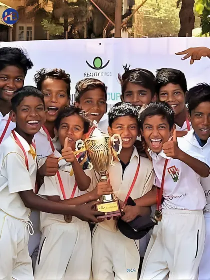 The joy of victory through our NGO partnerships. A team of young boys, supported by Reality Gives, celebrates with their trophy, showcasing the positive impact of our community sports programs.