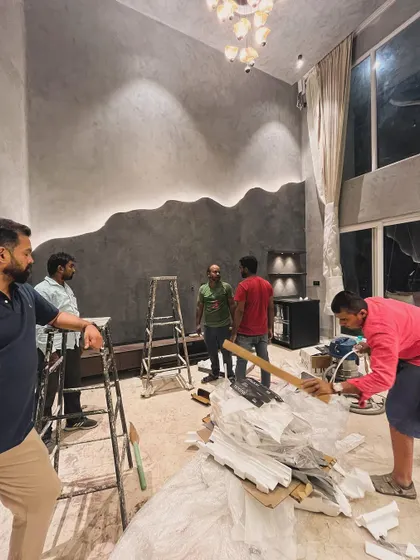 A late night on site as we push towards handover. The team gathers in the double-height living room, with its stunning wavy wall feature, to plan the final installations.